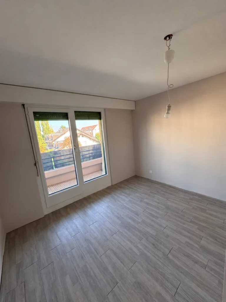 Pièce repeinte avec porte-fenêtre ouvrant sur un balcon